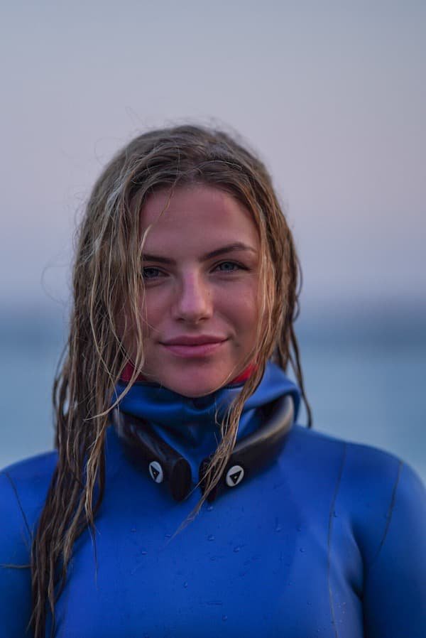 Blond woman in blue wetsuit smiling 