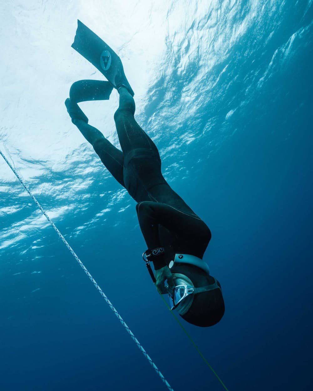 woman in wetsuit freediving at sea
