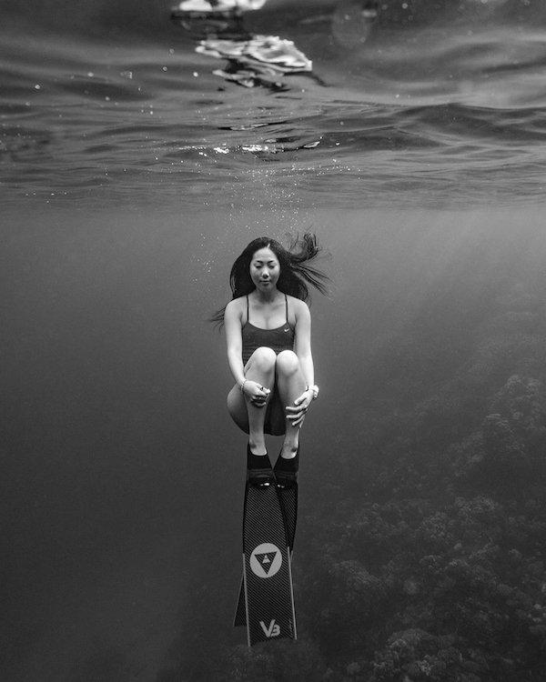 asian woman freediving at sea wearing alchemy v3 carbon fins