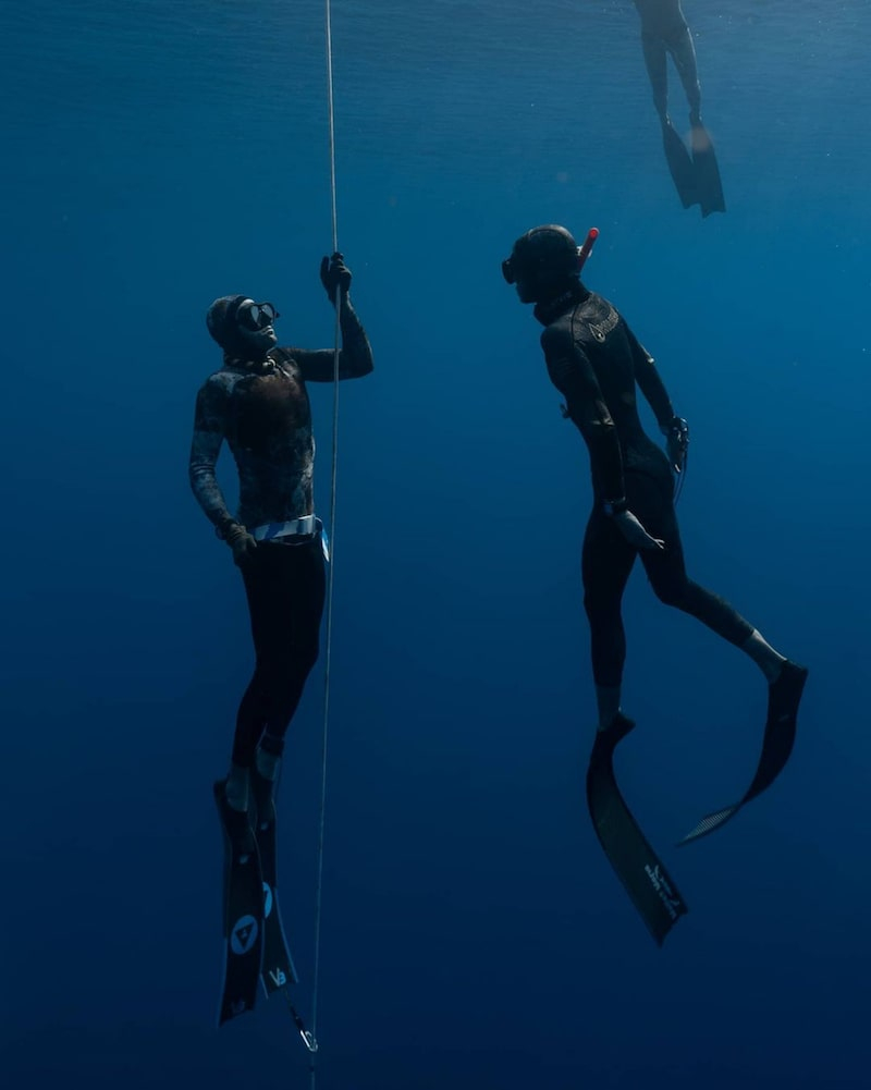 divers underwater in diving suits wearing alchemy v3 carbon fins