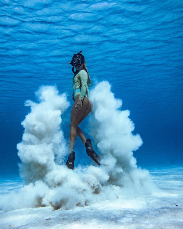 female freediver playing with the sand wearing alchemy v330 pro carbon fins