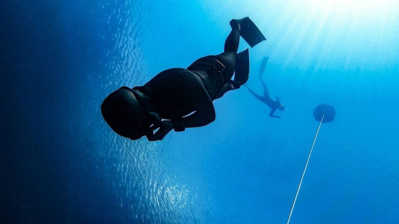 freediver underwater descending and wearing alchemy v330 carbon fins